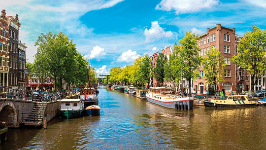 Houses lining the banks of a canal in Amsterdam